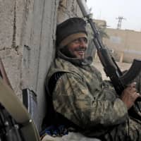 A member of Syria\'s Arab Shaytat tribe who has joined a Kurdish-led alliance fighting the Islamic State group in northern Syria, rests during his break on Sunday in the Syrian village of Baghouz. Numerous members of the Shaytat tribe have joined the fight to flush out the jihadis from a shrinking enclave near the Iraqi border. | AFP-JIJI