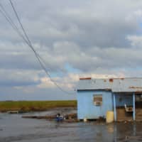 Water covers what was once a front yard on Isle De Jean Charles in Louisiana\'s Terrebonne Parish after Hurricane Gustav struck in September 2008. | KAREN APRICOT NEW ORLEANS, VIA WIKIMEDIA COMMONS / CC BY-SA 2.0