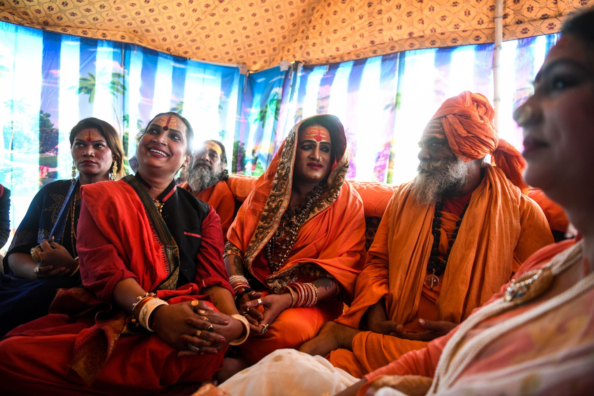 Laxmi Narayan Tripathi (center), a transgender rights activist and chief of the Kinnar Akhara monastic Hindu order made up of transgender members, meets with Hari Gigi (center right), head of the Hindu sadhu community Juna Akhara, at the Kumbh Mela festival in Prayagraj (formerly Allahabad) on Jan. 14. | AFP-JIJI