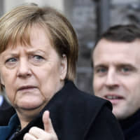 German chancellor Angela Merkel and French President Emmanuel Macron leave after the signing of a new Germany-France friendship treaty at the historic Town Hall in Aachen, Germany, on Tuesday. | AP
