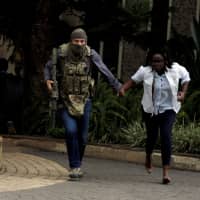 A security agent evacuates an injured woman from the scene where explosions and gunshots were heard at the Dusit hotel compound in Nairobi Jan. 15. | REUTERS