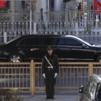A limousine believed to be carrying North Korean leader Kim Jong Un leaves a train station with a convoy in Beijing on Tuesday. | AP