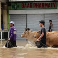 Filipinos in the flooded town of Baao in Camarines Sur province on Monday | AFP-JIJI