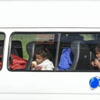 Two Venezuelan girls eat bread before being moved to a migrant camp in Bogota on Tuesday. Venezuelan President Nicolas Maduro &#8212; who swore in for a second term last week &#8212; is blamed by his detractors for the country\'s economic woes, which have left millions in poverty while another 2.3 million, according to the United Nations, have fled the country since 2015. | AFP-JIJI