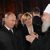 Russian President Vladimir Putin listens to Serbian Orthodox Church Patriarch Irinej talk as they visit the St Sava temple in Belgrade Thursday. | SPUTNIK / MIKHAIL KLIMENTYEV / KREMLIN / VIA REUTERS
