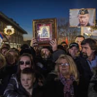 Supporters of Serbian President and Russian President Vladimir Putin wait for their arrival in front of Belgrade\'s Saint Sava Church on Thursday. Putin on Thursday called for stability in the Balkans during a pageantry-filled visit to Serbia, a key Moscow ally in a tense region on Europe\'s edge. | AFP-JIJI