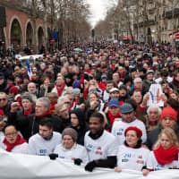 Opponents to the \"yellow vests\" violent behavior take part in a demonstration by the \"red scarves\" movement in Paris Sunday. | REUTERS