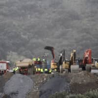 Drill and excavating machinery work on top of the mountain next to a deep borehole to reach a 2-year-old boy trapped there for six days near the town of Totalan in Malaga, Spain, Sunday. Spanish officials say rescuers are making slow progress in exceptionally difficult conditions to reach the 2-year-old boy who fell into a narrow, deep borehole in the countryside eight days ago. | ALEX ZEA / EUROPA PRESS / VIA AP