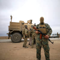 Syrian Democratic Forces and U.S. troops are seen during a patrol near Turkish border in Hasakah, Syria, in November. | REUTERS