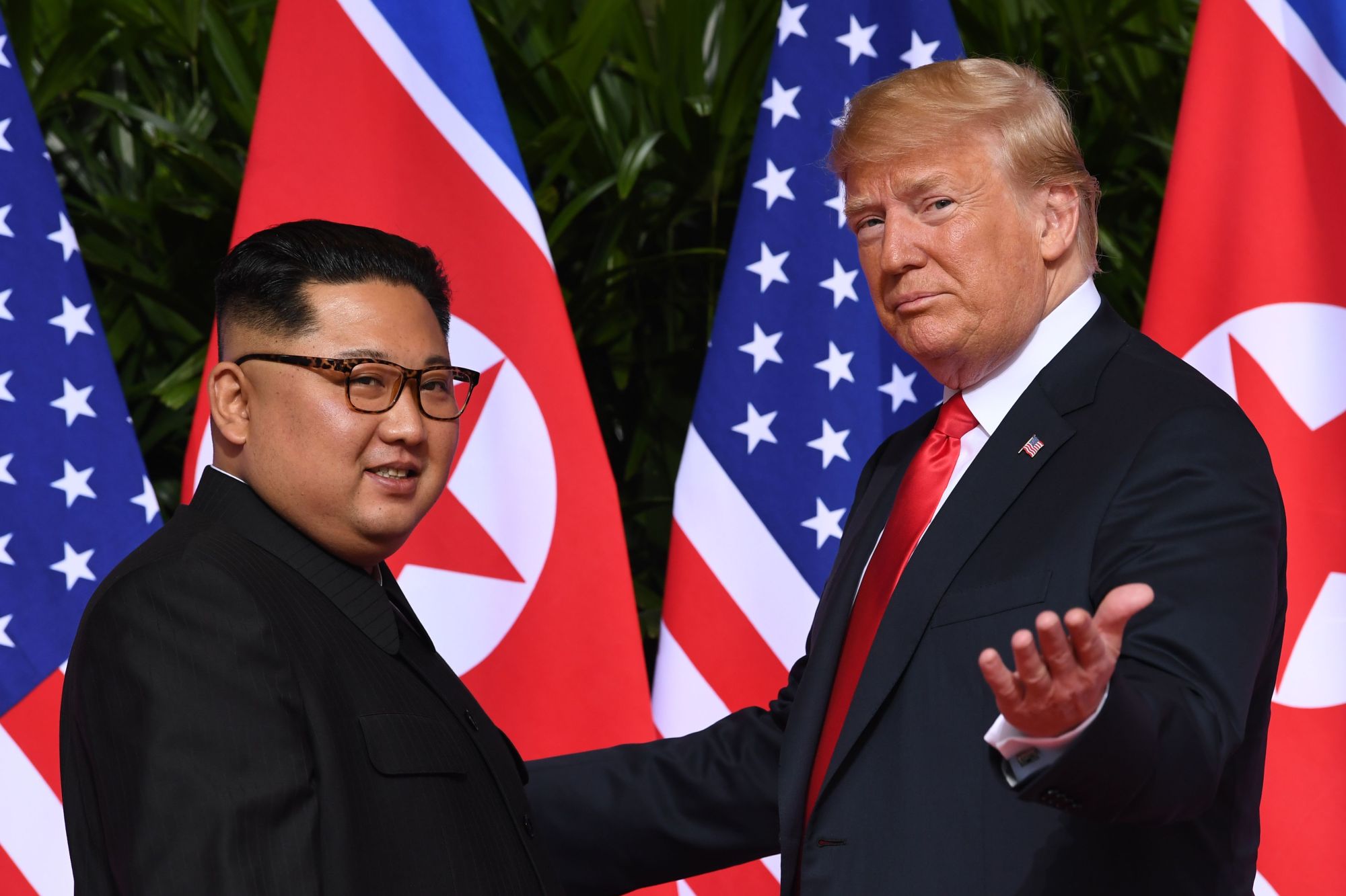 U.S. President Donald Trump gestures as he meets with North Korean leader Kim Jong Un at the start of their historic U.S.-North Korea summit at the Capella Hotel on Sentosa island in Singapore last June. Trump said Sunday negotiations are underway on the location of the next summit with Kim. | AFP-JIJI