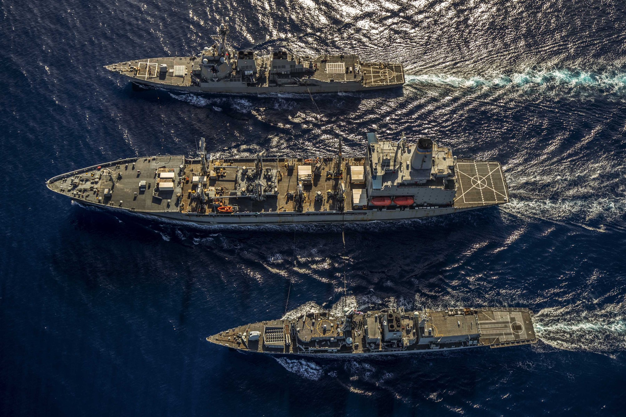The HMS Argyll (bottom) takes part in a replenishment at sea with the USS McCampbell (top) and USNS Henry J Kaiser while operating in the South China Sea on Saturday. | ROYAL NAVY