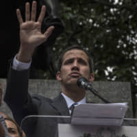 Juan Guaido, the president of the National Assembly who has sworn himself in as the president of Venezuela, addresses a rally at Bolivar Square in Caracas on Friday. | BLOOMBERG