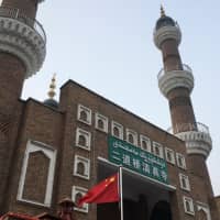 The Chinese national flag flies outside the mosque at the Xinjiang International Grand Bazar during a government-organized trip in Urumqi, Xinjiang Uighur Autonomous Region, China, on Jan. 3. | REUTERS