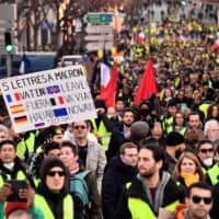 People march in Marseille on Saturday during a demonstration against the high cost of living, government tax reforms and for more \"social and economic justice.\" | AFP-JIJI