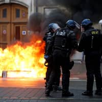 French Gendarmes stand near a fire during a demonstration of the \"yellow vests\" movement in Strasbourg, France, Saturday. | REUTERS