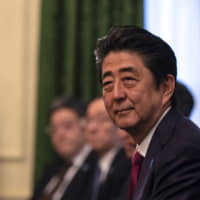 Prime Minister Shinzo Abe listens during a meeting with his U.K. counterpart Theresa May in London on Jan. 10. | BLOOMBERG