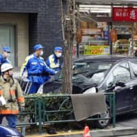 A car is seen on a sidewalk near JR Shinjuku Station in Tokyo on Wednesday after its diver hit and injured five people. | KYODO