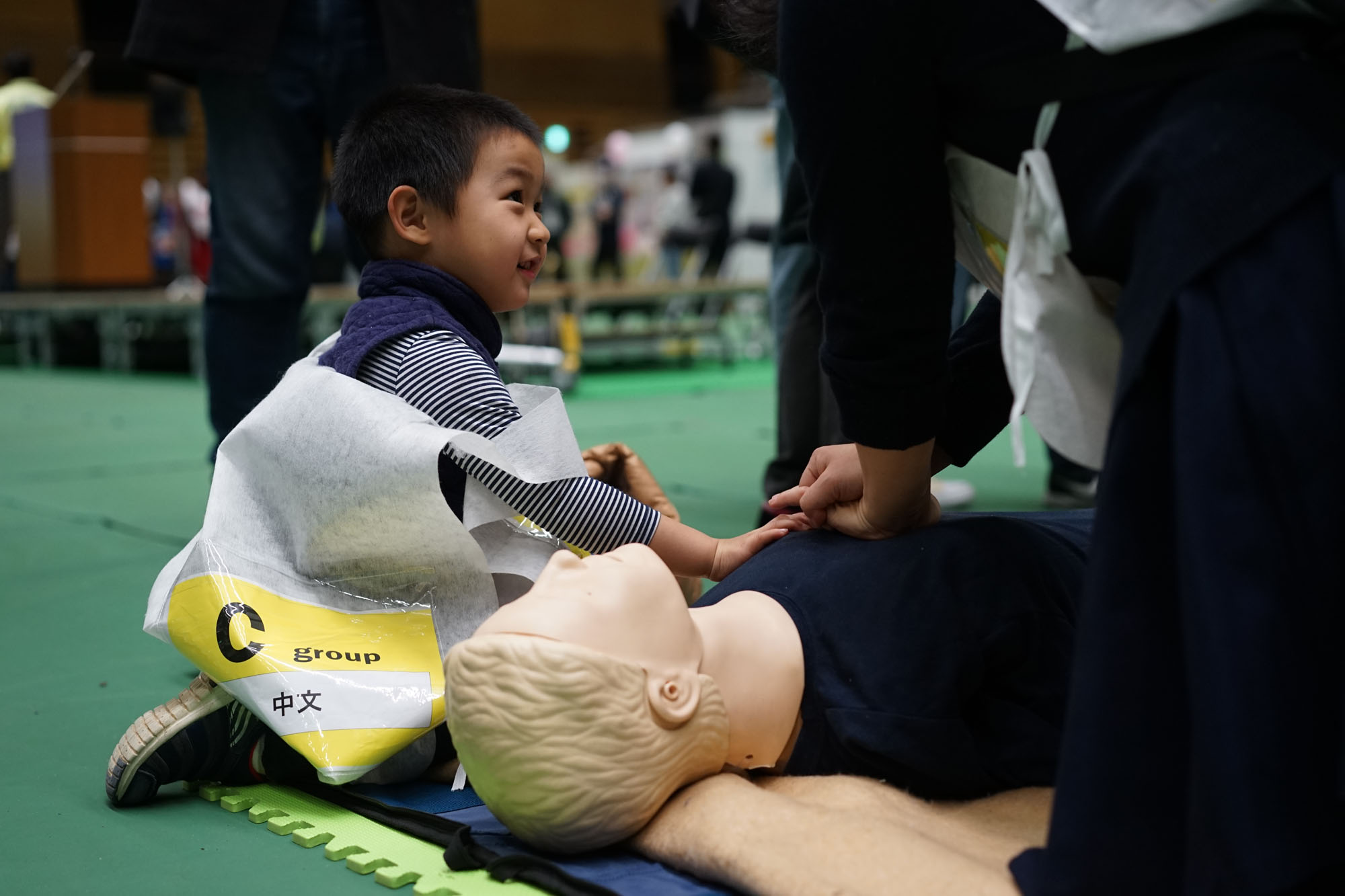 Li Wu Yi Feng, 4, helps his mother 'resuscitate' a practice dummy during a drill for foreign residents held Wednesday in Setagaya Ward, Tokyo. | RYUSEI TAKAHASHI