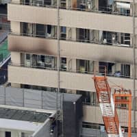 Two people were killed and 13 were injured in a fire early Friday at this lodging house in Yokohama. | KYODO