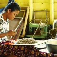 A woman processes banana tree fibers in the village of Anlong Pi, near Cambodia\'s famous tourist destination Siem Reap. | COURTESY OF TAKUYA YAMASE