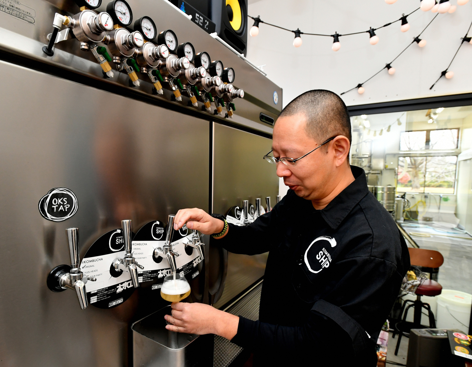 Shimada pours a glass of kombucha at Oizumi Kojo’s kombucha brewery in Kawaguchi, Saitama Prefecture.