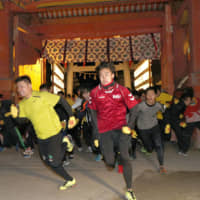 Runners, including eventual winner Yuki Yamamoto (left), on Thursday sprint toward the main hall of Nishinomiya Shrine in Hyogo Prefecture in hopes of earning this year’s title of “Lucky Man.” | KYODO
