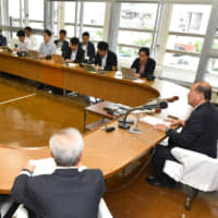 Ginowan Mayor Masanori Matsugawa (far right) announces his decision that a prefectural referendum will not be held in the city, at the Ginowan municipal office on Dec. 25. | THE OKINAWA TIMES
