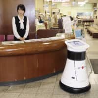 This robot, which waits at the entrance of Ogaki City Hall, has been introduced recently to guide visitors to the right information window. | KYODO