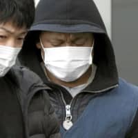 A suspect arrested in a case involving an online romance scam is taken to Fukuoka Prefecture on Tuesday. | KYODO