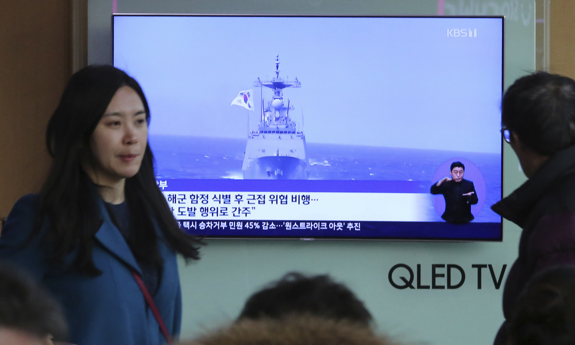 File footage of a South Korean warship is shown during a TV news program viewed at the main railway station in Seoul on Wednesday. | AP