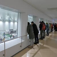 People watch tuna auctions from a second-floor corridor at the Toyosu fish market in Tokyo on Tuesday. | SAKURA MURAKAMI
