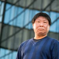 Author Takeshi Goto poses for a photo in Yokohama in December. | ROBERT GILHOOLY