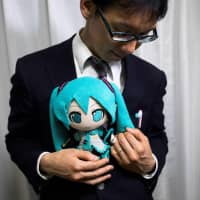Akihito Kondo with a figurine of his \"wife,\" Hatsune Miku. | AFP-JIJI
