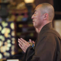 I can do anything: A monk prays at Chionji temple in Kyoto. Other monks took to social media to protest a ticket given to one of their own by a police officer in Fukui Prefecture. | GETTY IMAGES
