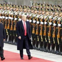 U.S. President Donald Trump reviews an honor guard with Chinese President Xi Jinping in 2017. The rise of China presents America with its greatest challenge since the Cold War. | BLOOMBERG