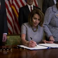 U.S. House Speaker Nancy Pelosi, a Democrat from California, signs a deal to end a partial government shutdown at the U.S. Capitol in Washington on  Jan. 25. | BLOOMBERG
