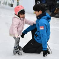 Takahiko Kozuka assists a young skater during a lesson at one of his Kozuka Academy classes last Saturday. | YOSHIAKI MIURA