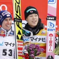 Ryoyu Kobayashi (right) poses with FIS Ski Jumping World Cup event-winner Stefan Kraft of Austria on Sunday in Sapporo. Kobayashi finished in third to reach the podium for the first time in four meets. | KYODO