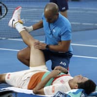 Kei Nishikori receives treatment during his quarterfinal match against Novak Djokovic at the Australian Open on Wednesday. | AP