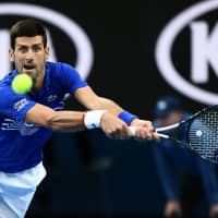 Novak Djokovic hits a return against Lucas Pouille during their semifinal match at the Australian Open on Friday. | AFP-JIJI