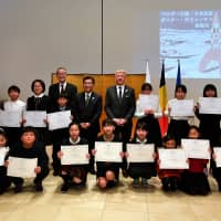 Students holding certificates pose for a photo during an awards ceremony for a poster and essay writing competition titled \"Kingdom of Belgium: Japan Friendship\" at the Belgian Embassy in Tokyo on Jan. 10.  Belgian Ambassador Gunther Sleeuwagen (fifth from right) stands beside Keizo Nakai, director-general of the Office of Education at the Tokyo Metropolitan Board of Education, and Belgian Japanese Accademic Society President Kazuo Kitahara. | YOSHIAKI MIURA