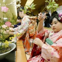 Flower powerGirls in kimono arrange flowers on Saturday during this year\'s first lesson at the Ikenobo flower arrangement school in Kyoto. About 1,500 people between the ages of 8 and 95 participated in the meeting of Japan\'s oldest ikebana school, which traces its history back more than 550 years. | KYODO