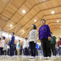 Children attend a ceremony Friday marking the start of a new semester at Kesen Elementary School in Rikuzentakata, Iwate Prefecture. The school is the last public school in the prefecture heavily damaged by the 2011 earthquake and tsunami to be rebuilt. | KYODO
