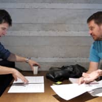 Manzai comedian Patrick Harlan (left) and Japan Times reporter Andrew McKirdy fine-tune a manzai routine. | CHISATO TANAKA