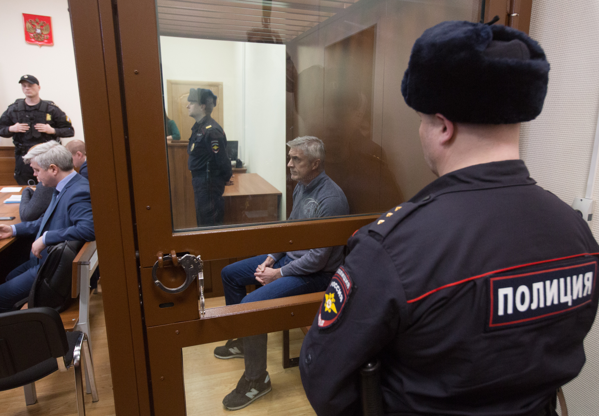 Michael Calvey, founder of private-equity firm Baring Vostok Capital Partners, sits in a security booth during a hearing at the Basmanny District Court in Moscow Feb. 16. A Russian court ruled that Calvey, one of the country's longest-standing American investors, should be held in custody for nearly two months in an embezzlement case. | BLOOMBERG