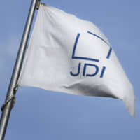 The Japan Display Inc. corporate flag files outside the company\'s plant in Mobara, Chiba Prefecture. | BLOOMBERG