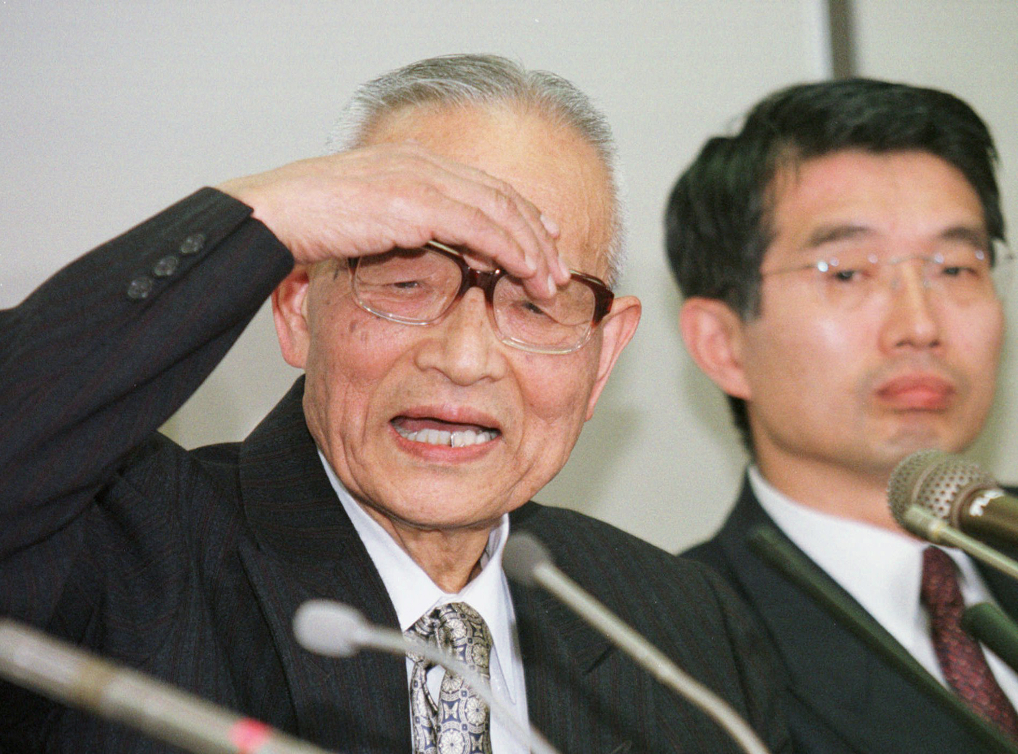 Takeshi Abe, a professor and former vice president of Teikyo University, speaks next to his attorney, Junichiro Hironaka, during a 1997 news conference after testifying in the first of several trails in a widespread AIDS scandal at the Tokyo District Court. Carlos Ghosn has hired Hironaka as part of his legal team. | AP