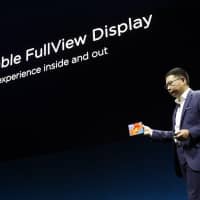 Richard Yu, chief executive officer of Huawei Technologies Co., presents the Mate X foldable 5G mobile device during a launch event in Barcelona, Spain, on Sunday. | BLOOMBERG