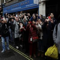 Spectators use their smartphones to record performers during the Chinese New Year parade through central London on Sunday. | REUTERS
