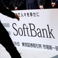 A SoftBank Corp. placard is prepared during a ceremony Dec. 19 to mark the company\'s debut on the Tokyo Stock Exchange. | REUTERS